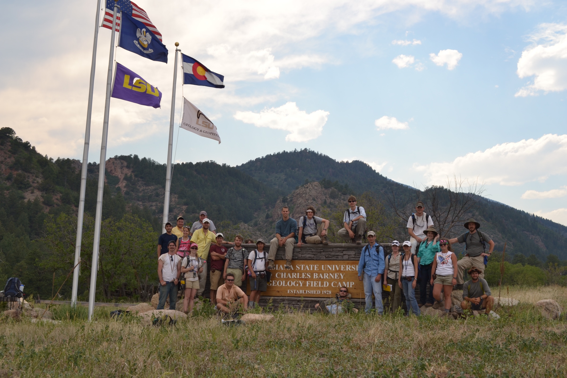 Students posing around the entrance sign to the field camp.